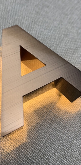 Chữ inox xước hồng gắn đèn Led sáng hắc chân